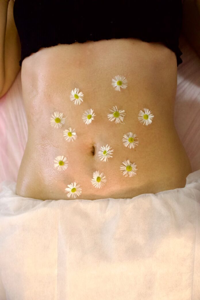 Когда женский кортизол уходит — уходит и спасательный круг живота Woman's belly adorned with calming chamomile flowers for relaxation therapy.