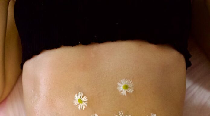 Когда женский кортизол уходит — уходит и спасательный круг живота Woman's belly adorned with calming chamomile flowers for relaxation therapy.